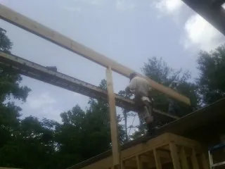 Carpenter setting a ridge beam over a new addition frame — Ice Dam Removal by Roofing Brothers in Mc Kees Rocks