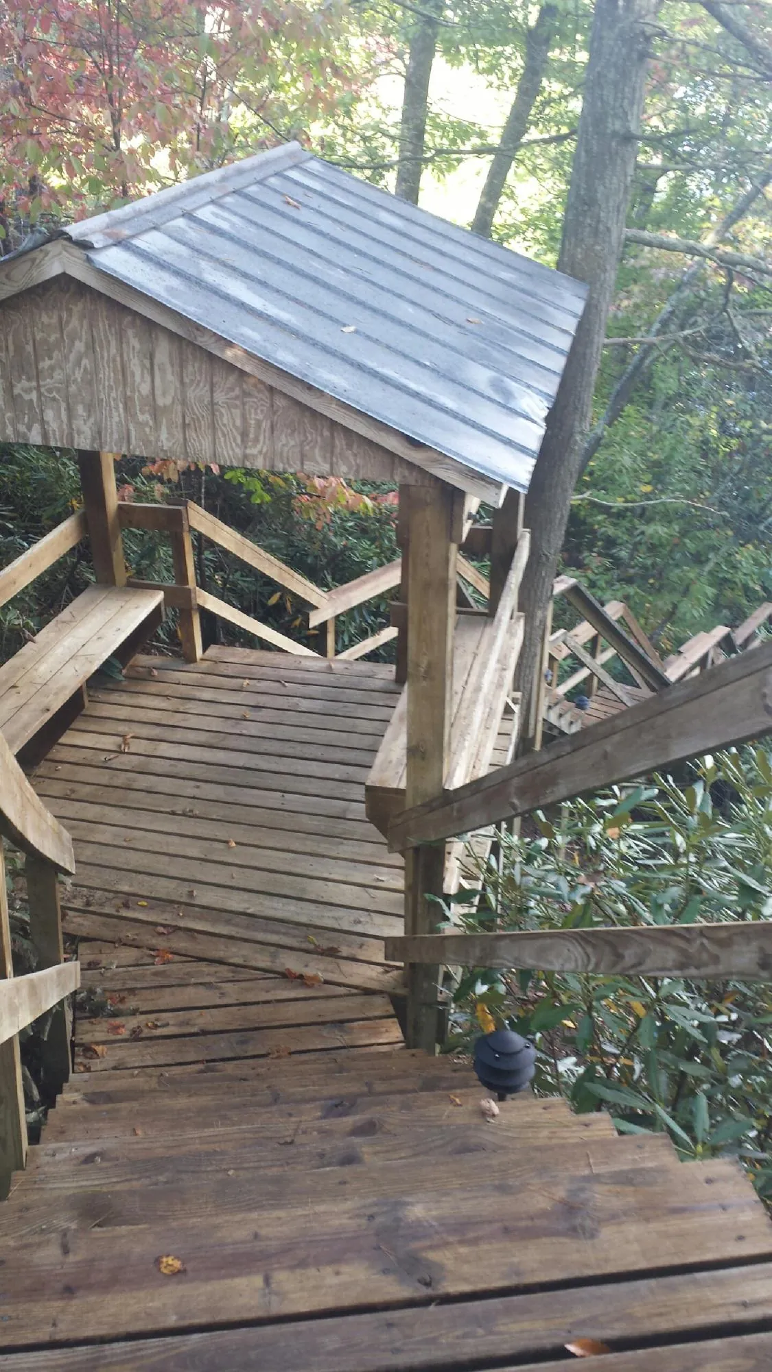 Metal roofed shelter over wooden steps on a wooded walkway — Skylight Repair & Installation work by our crew in Mc Kees Rocks
