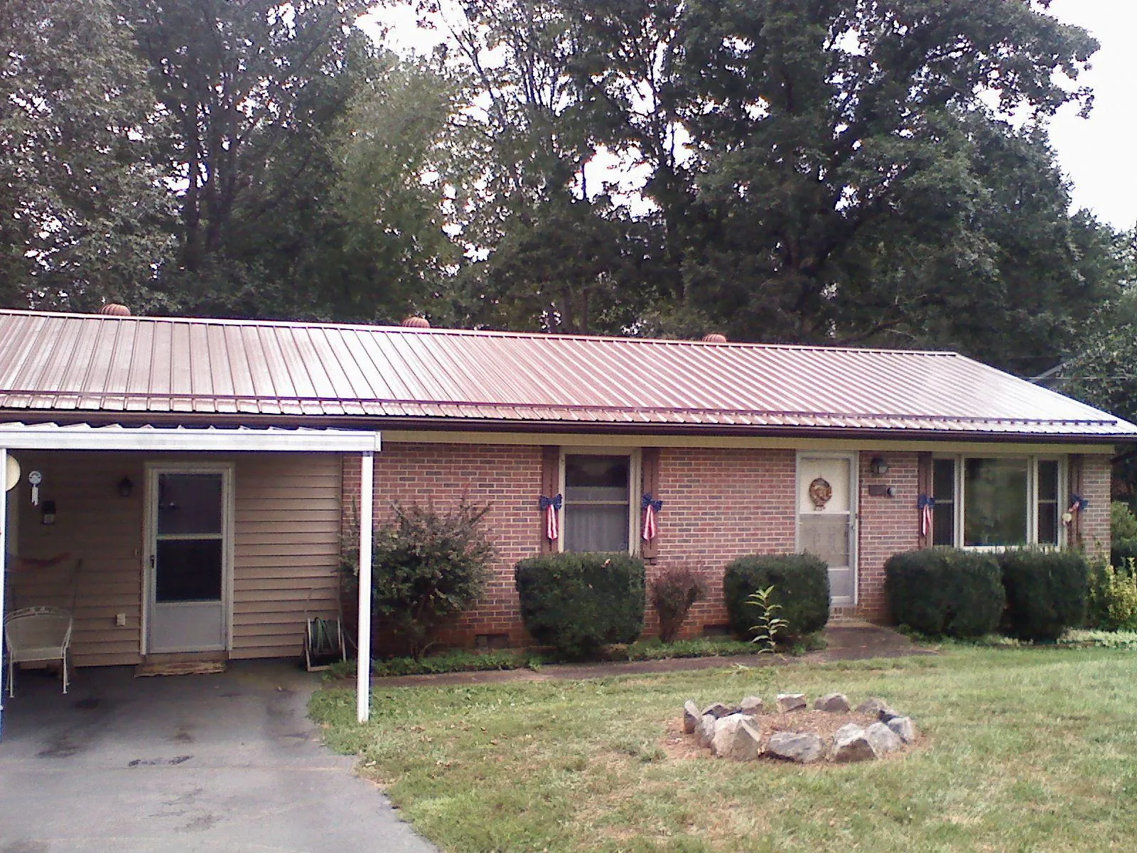Bronze metal roof and carport on a brick ranch home — Roof Repair work by our crew in Mc Kees Rocks